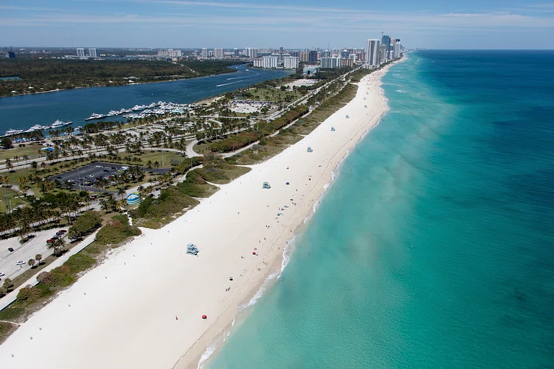 A serene Florida beach at sunset, showcasing the powdery sands typical of the state's Gulf Coast shores.