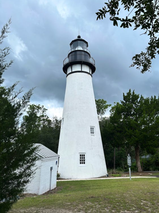 The historic Amelia Island Lighthouse stands tall against a cloudy sky at Fernandina Beach.
