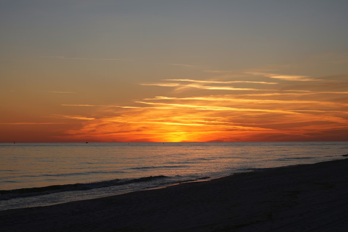 A breathtaking Florida sunset with endless orange skies reflecting on the tranquil Gulf waters.