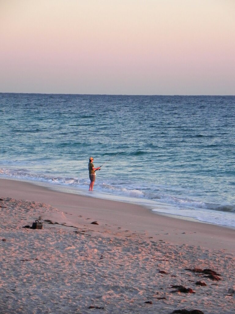 A man fishing at the shore of Vero beach.